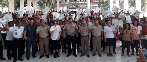 Bupati Vonnie Panambunan foto bersama warga penerima sertifikat.