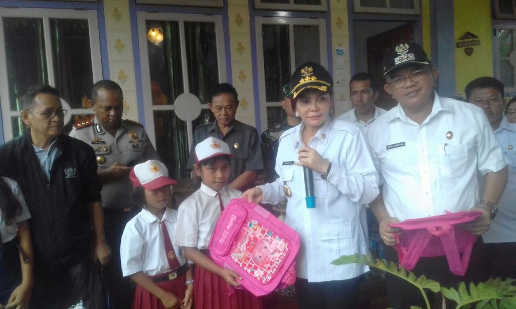 Bupati VAP dan Wakil Bupati Joppi Lengkong membagikan bantuan tas sekolah.