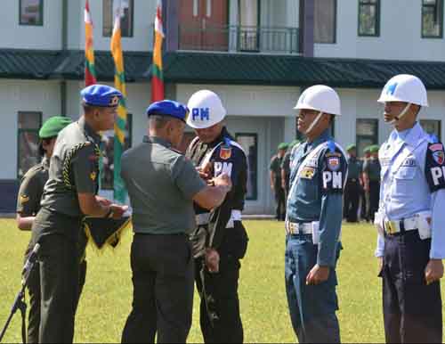 Pangdam Merdeka Mayjen TNI Ganip Warsito memasang tanda operasi kepada perwakilan polisi militer dari masing-masing angkatan. 